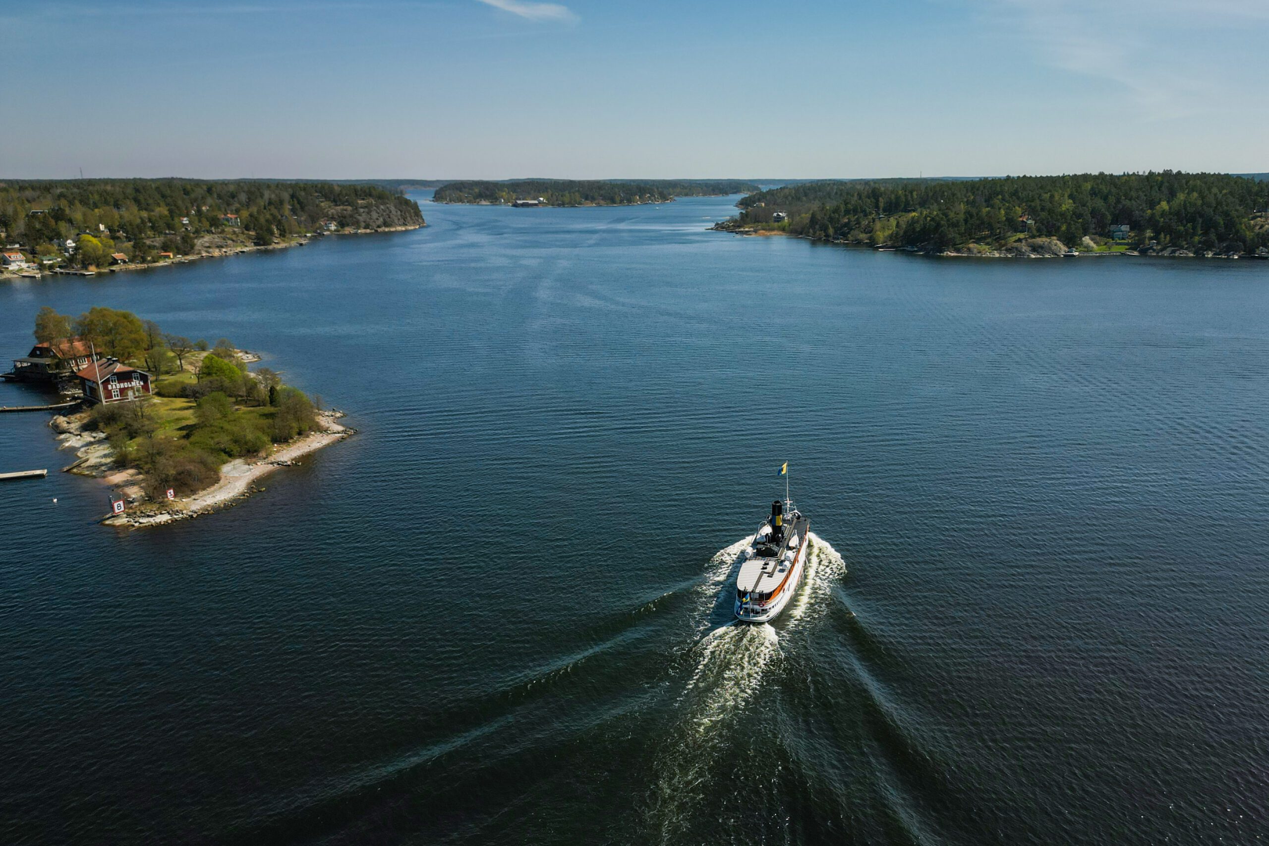 Ångfartyget Blidösund åker i vattnet i Stockholms skärgård, blå himmel och hav
