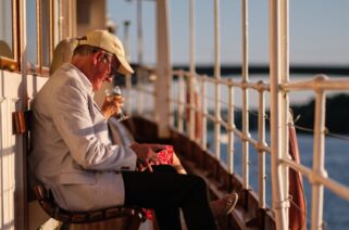 Two elderly people sitting out on deck enjoying the sun on the boat Blidsöund,