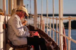 Två äldre människor som sitter ute på däck och njuter av sol på båten Blidsöund,