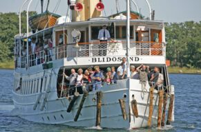 Ångbåten Blidösund med fullt på fördäck med passagerare i en solig dag omkring Norrtälje trakten i Stockholms skärgård